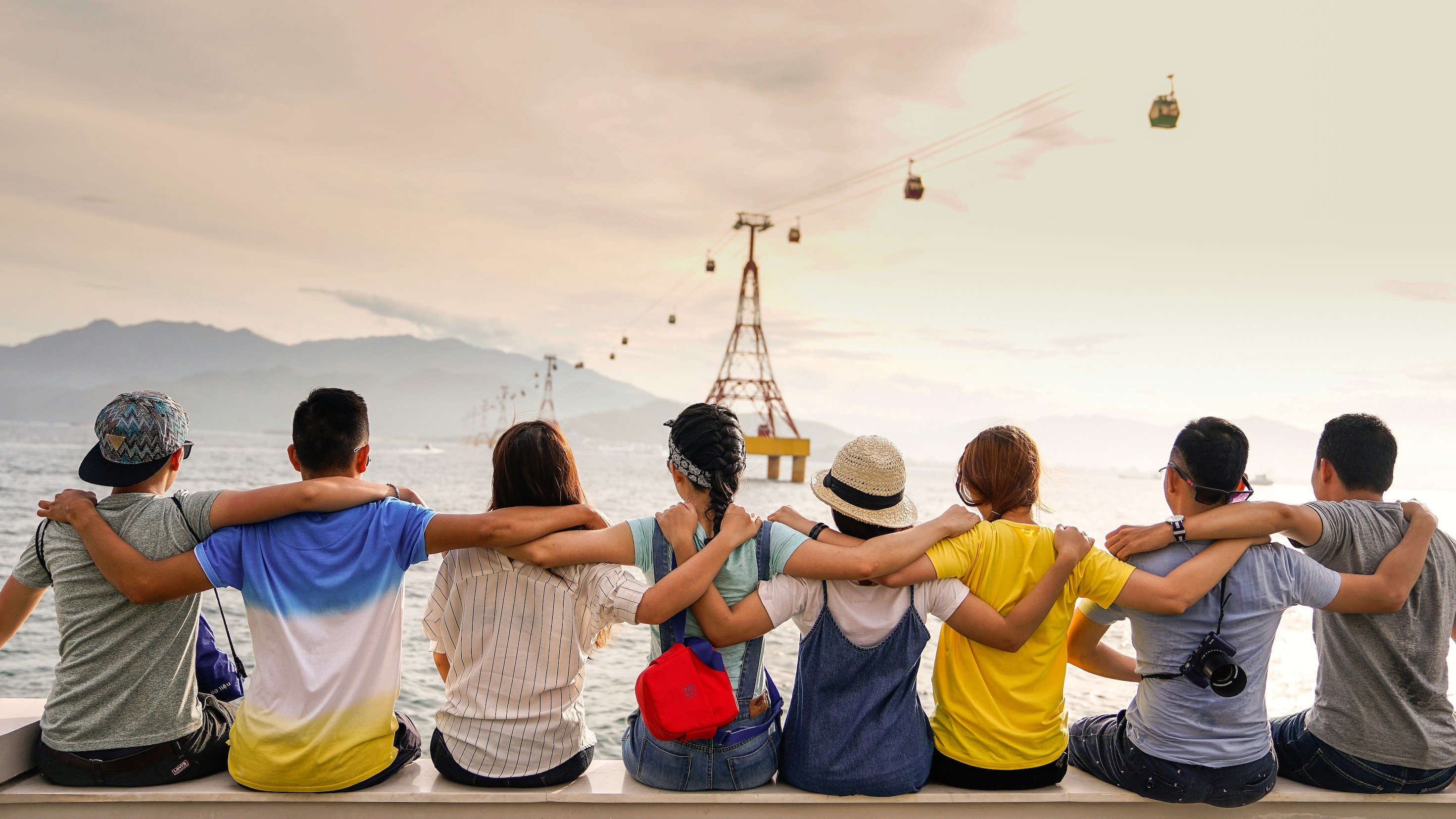 Group of friends hugging while enjoying a scenic travel view