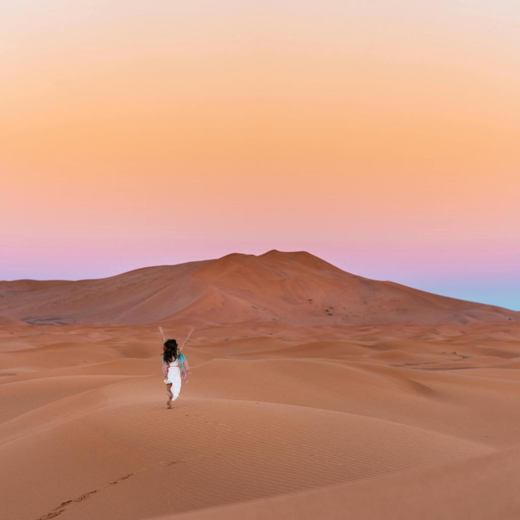 Solo traveller in remote sand dunes at sunset, no crowds